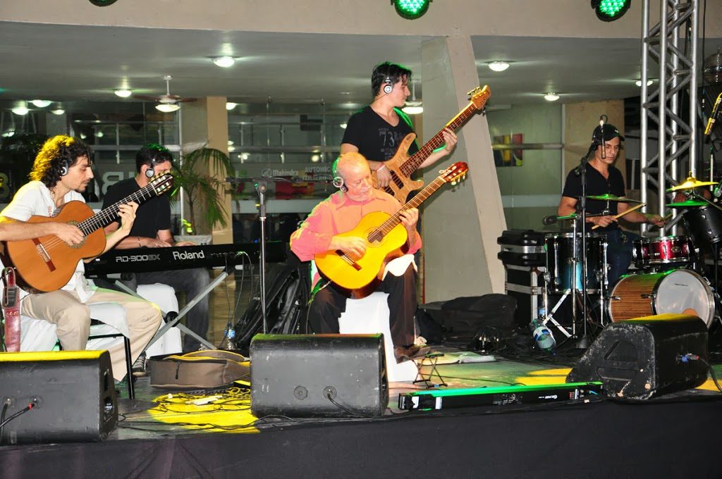 Sebastião Tapajós tocando violão com banda no palco