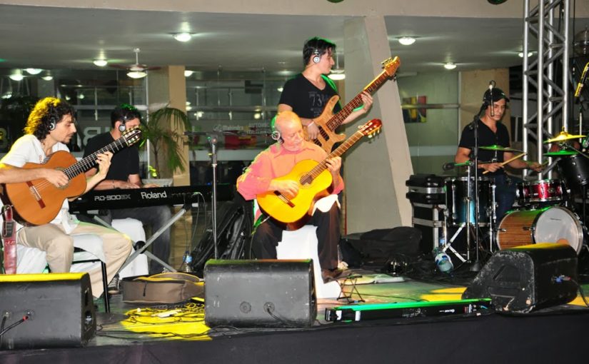 Sebastião Tapajós tocando violão com banda no palco